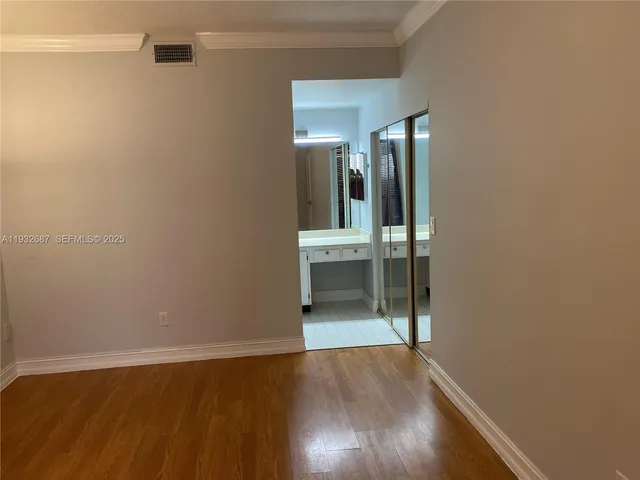 an empty room with wooden floor and mirror