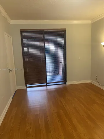 an empty room with wooden floor and door