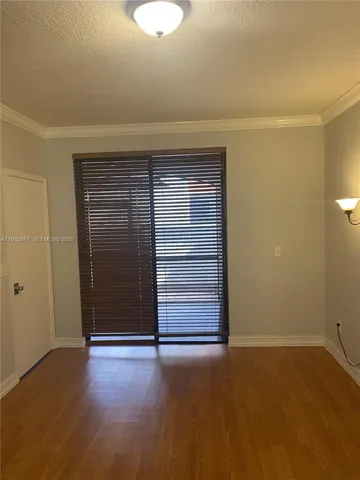 a view of an empty room with closet and a window