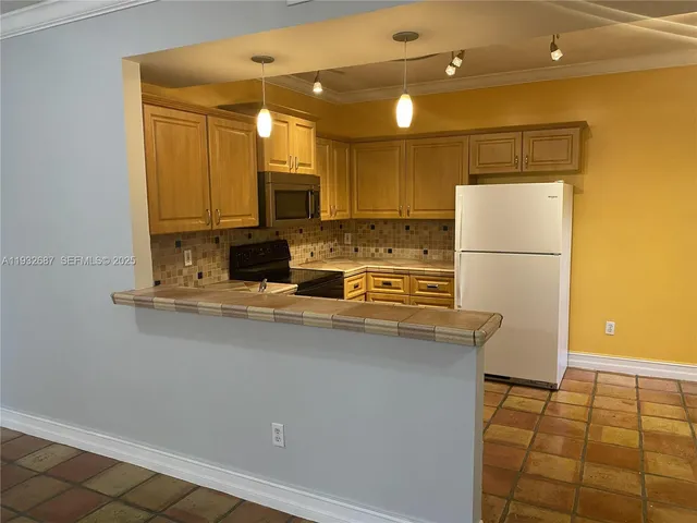 a kitchen with stainless steel appliances a refrigerator sink and microwave