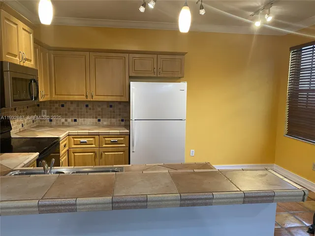 a kitchen with kitchen island a stove and a refrigerator
