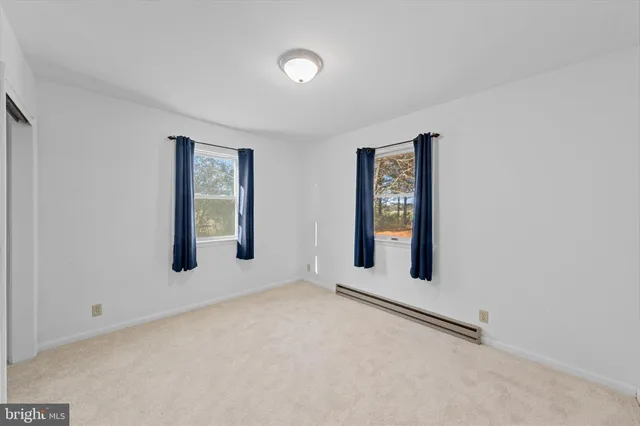 an empty room with windows and closet