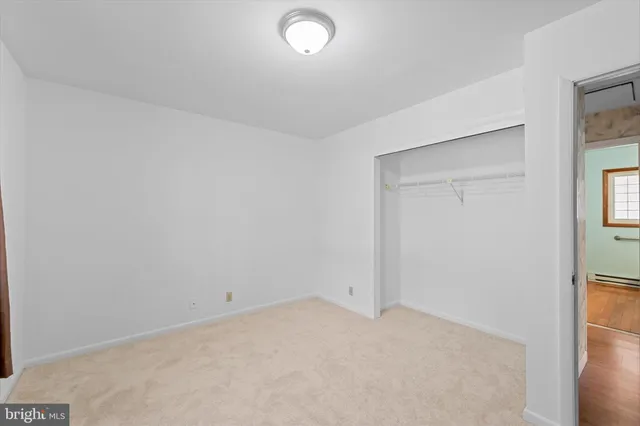an empty room with windows and closet