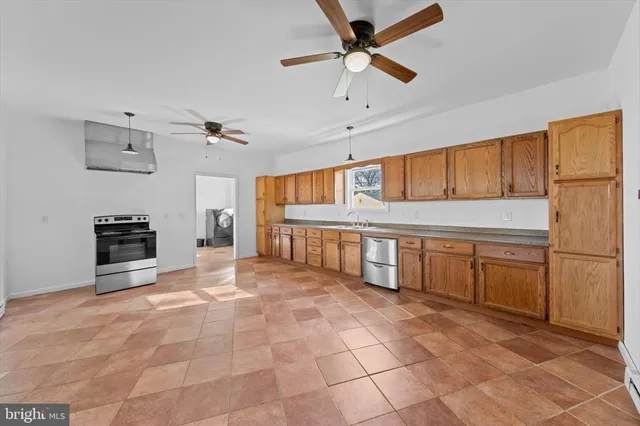 a large white kitchen with a stove a refrigerator and a stove top oven