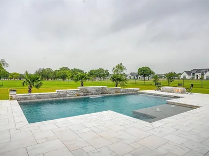 a view of swimming pool with outdoor seating and green space