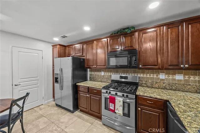 a kitchen with stainless steel appliances granite countertop a refrigerator stove and oven