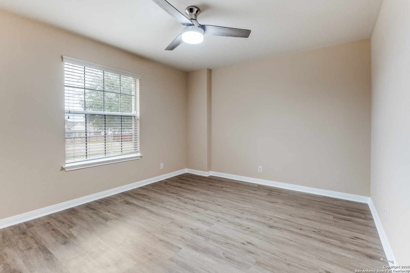 1935 Walter Raleigh Windcrest, TX 78239 - Photo 17 of 27 a view of an empty room with wooden floor and a window