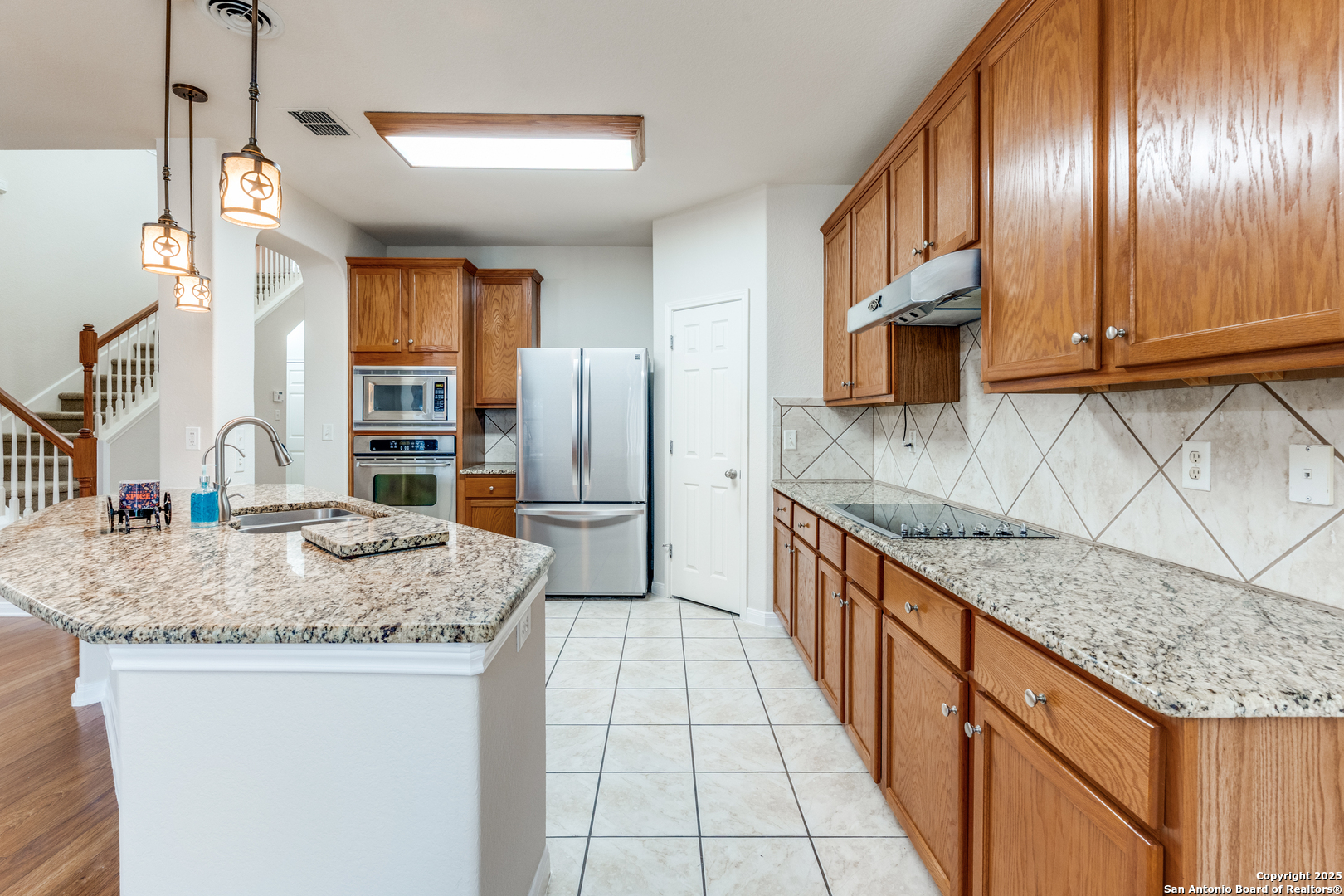 1935 Walter Raleigh Windcrest, TX 78239 - Photo 7 of 27 a kitchen with stainless steel appliances granite countertop a sink a stove and a refrigerator