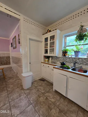 a kitchen with a sink and chairs