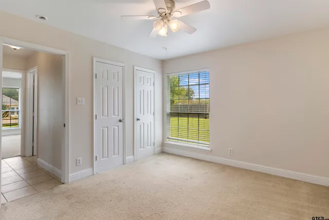 an empty room with fan and windows