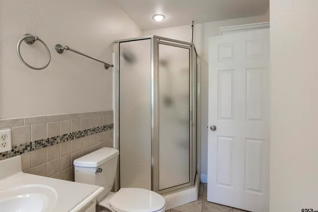 a bathroom with a granite countertop toilet sink and shower