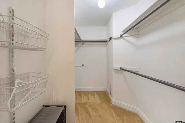 a view of walk in closet with empty racks