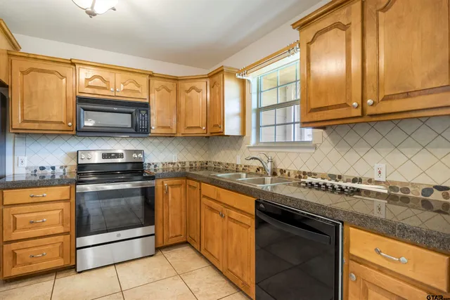 a kitchen with stainless steel appliances granite countertop a sink stove and microwave