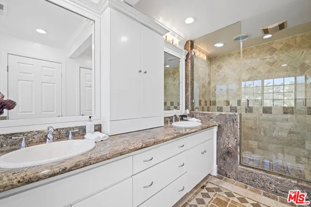 a bathroom with a granite countertop double vanity sink mirror and