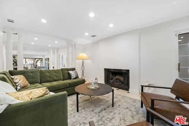a living room with furniture a refrigerator and a table