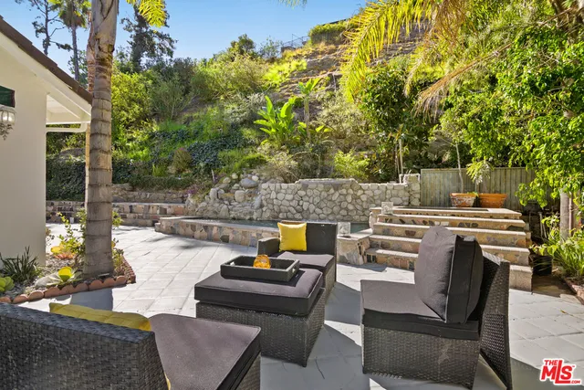 a view of a house with backyard and sitting area