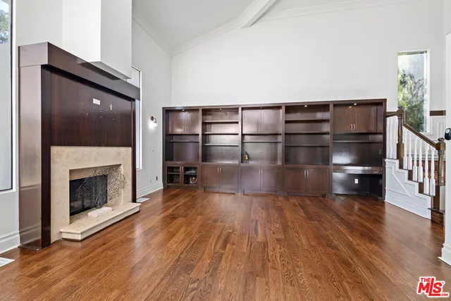 a view of a livingroom with wooden floor and a fireplace