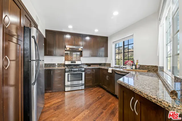 a kitchen with granite countertop stainless steel appliances and wooden cabinets
