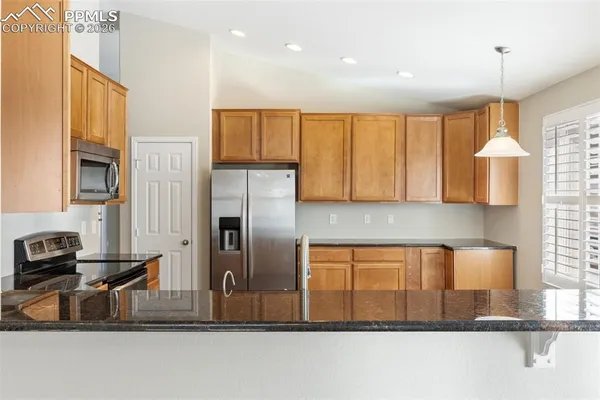 a kitchen with stainless steel appliances granite countertop a sink refrigerator and cabinets
