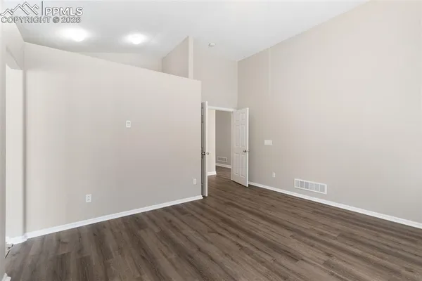 a view of an empty room with wooden floor
