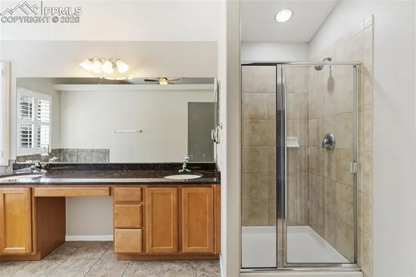 a bathroom with a granite countertop sink a mirror and a shower