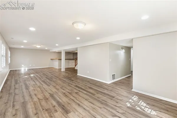 a view of empty room with wooden floor