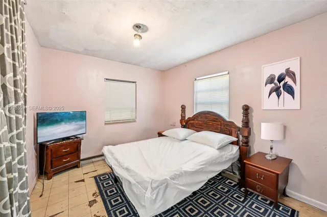 a bedroom with a bed and a tv on the dresser