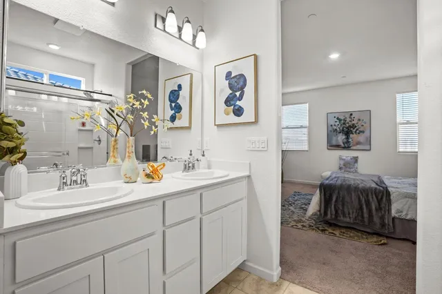 a en suite bathroom with double vanity sinks a mirror and a shower