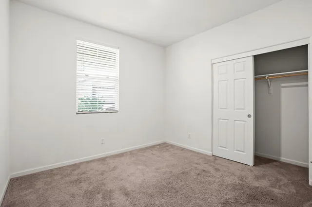 an empty room with windows and closet