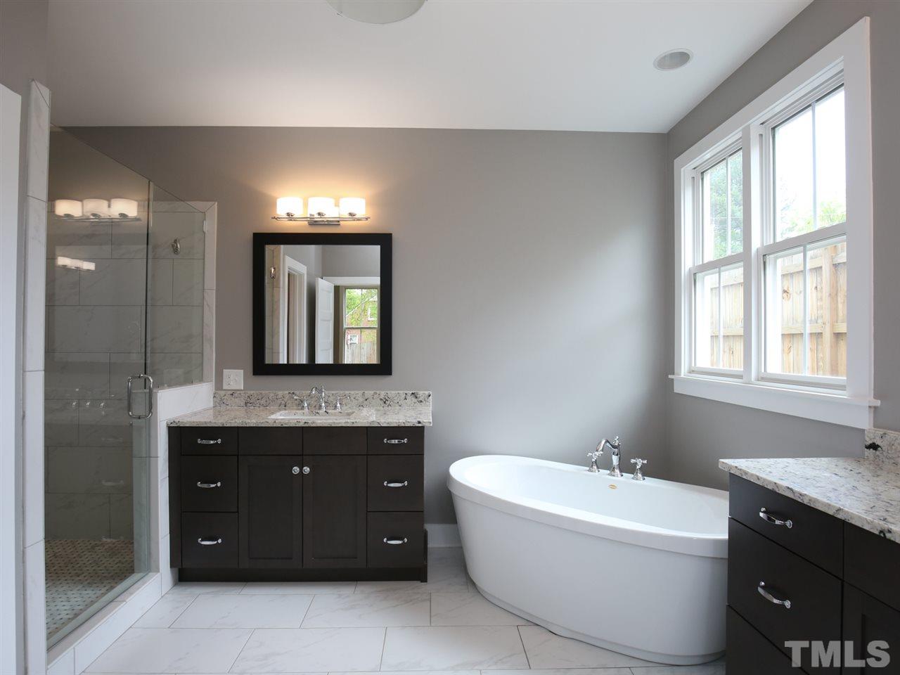 1101 North State Street Raleigh, NC 27604 - Photo 16 of 25 a spacious bathroom with a granite countertop sink and a mirror