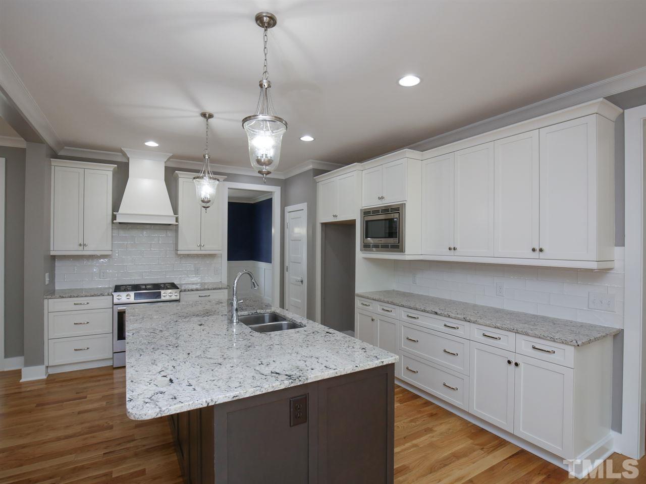 1101 North State Street Raleigh, NC 27604 - Photo 8 of 25 a kitchen with stainless steel appliances granite countertop a sink refrigerator and cabinets
