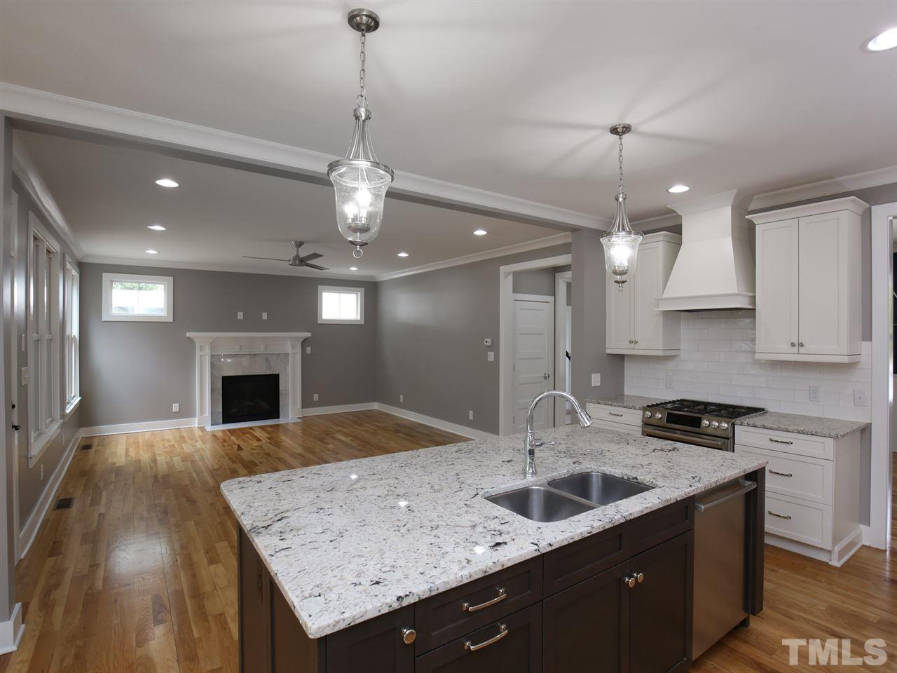 1101 North State Street Raleigh, NC 27604 - Photo 9 of 25 a kitchen with kitchen island a sink center island a stove cabinets and living room view