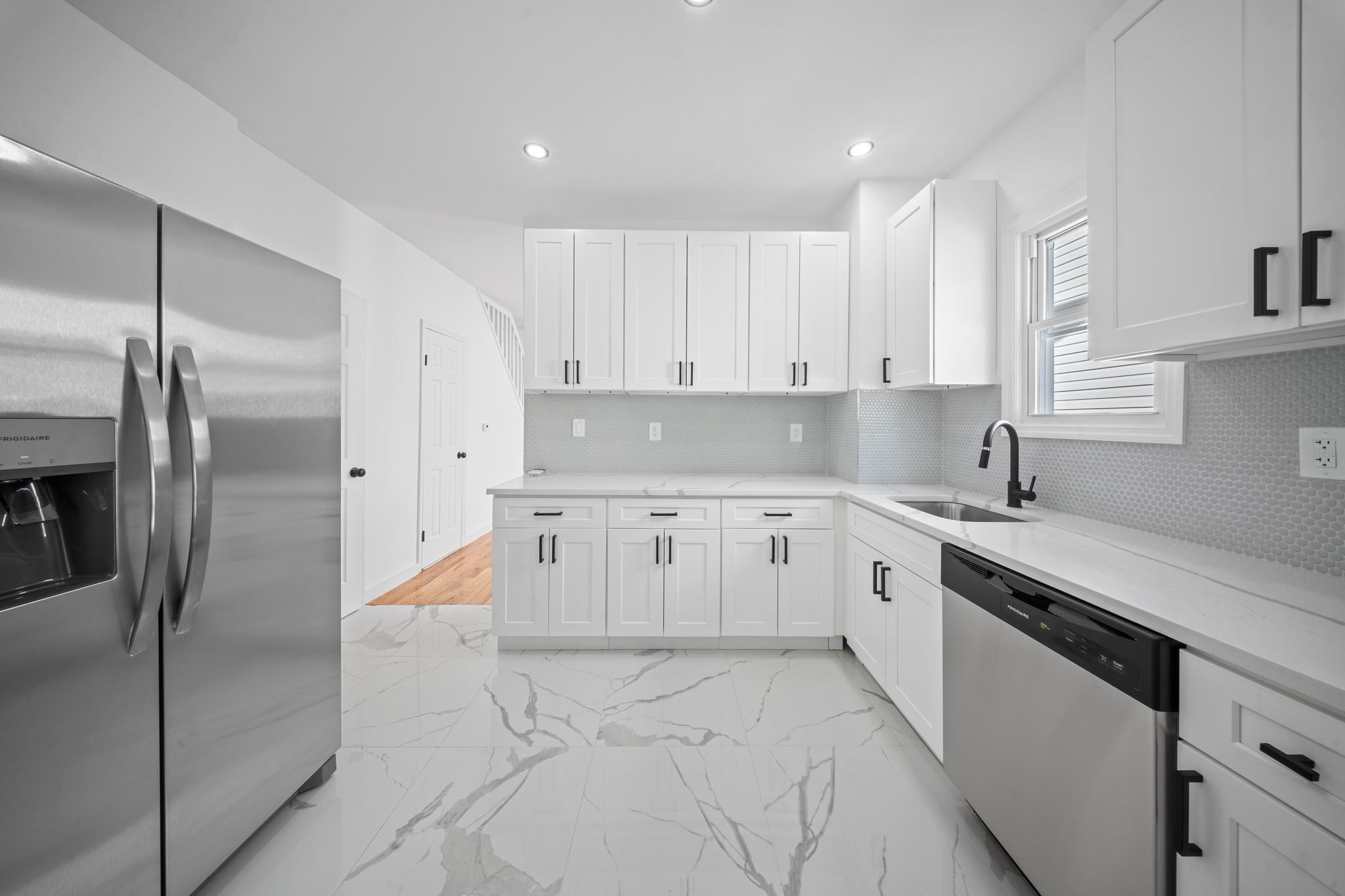 a kitchen with a refrigerator sink and cabinets