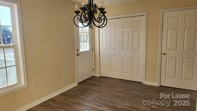 a view of a room with wooden floor and a window