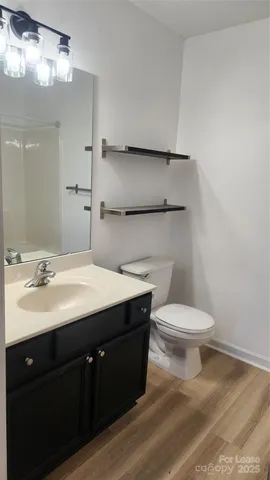 a bathroom with a sink vanity mirror and toilet