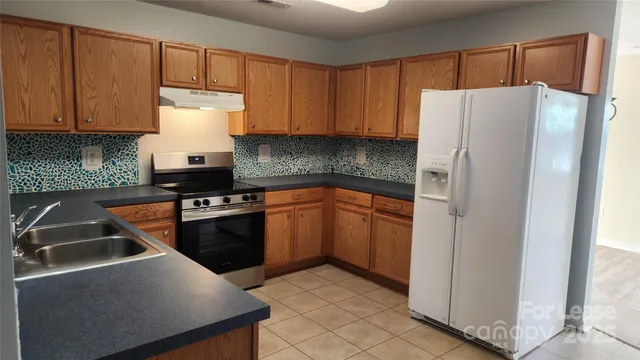 a kitchen with stainless steel appliances a refrigerator sink and cabinets