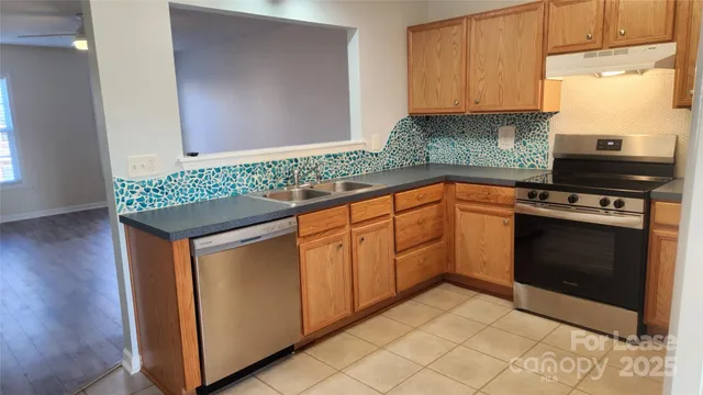 a kitchen with granite countertop cabinets stainless steel appliances and a counter space
