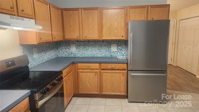 a kitchen with stainless steel appliances granite countertop a refrigerator and a stove