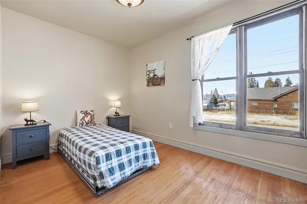 a bedroom with a bed lamp and a large window