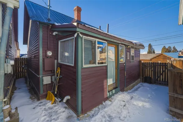 a view of a house with a door and wooden fence