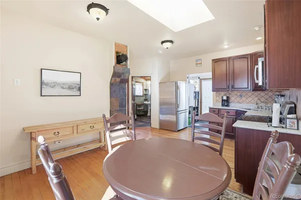 a living room with stainless steel appliances furniture a couch and a kitchen view