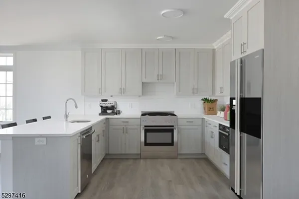 a kitchen with cabinets stainless steel appliances and sink