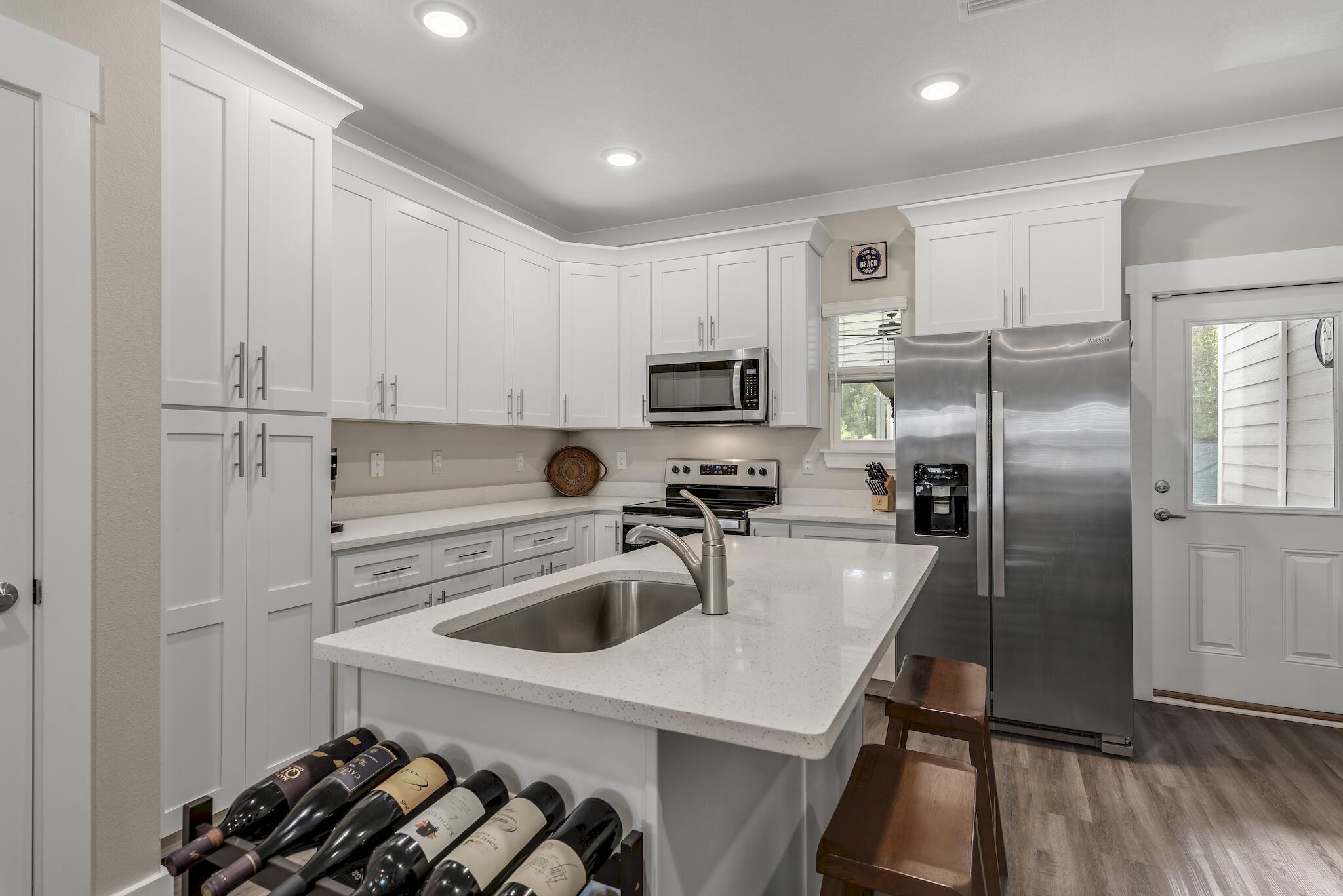 157 North Sand Palm Road Freeport, FL 32439 - Photo 3 of 24 a kitchen with a sink a refrigerator and cabinets