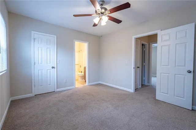 an empty room with closet and a ceiling fan