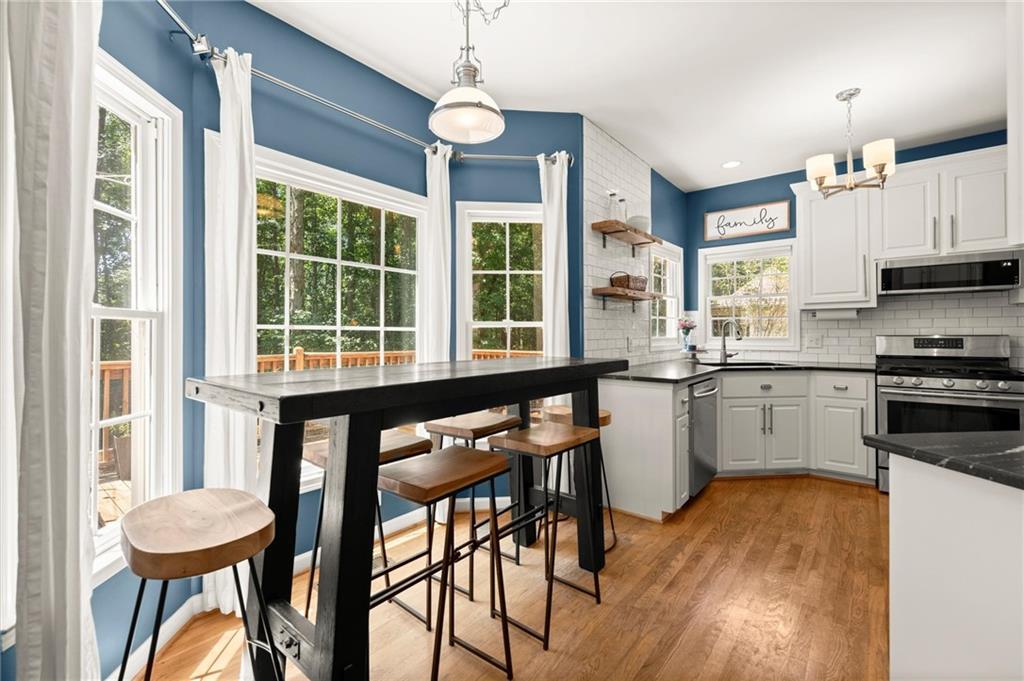 313 Thorntree Lane Canton, GA 30115 - Photo 13 of 51 a kitchen with a table chairs stove and cabinets