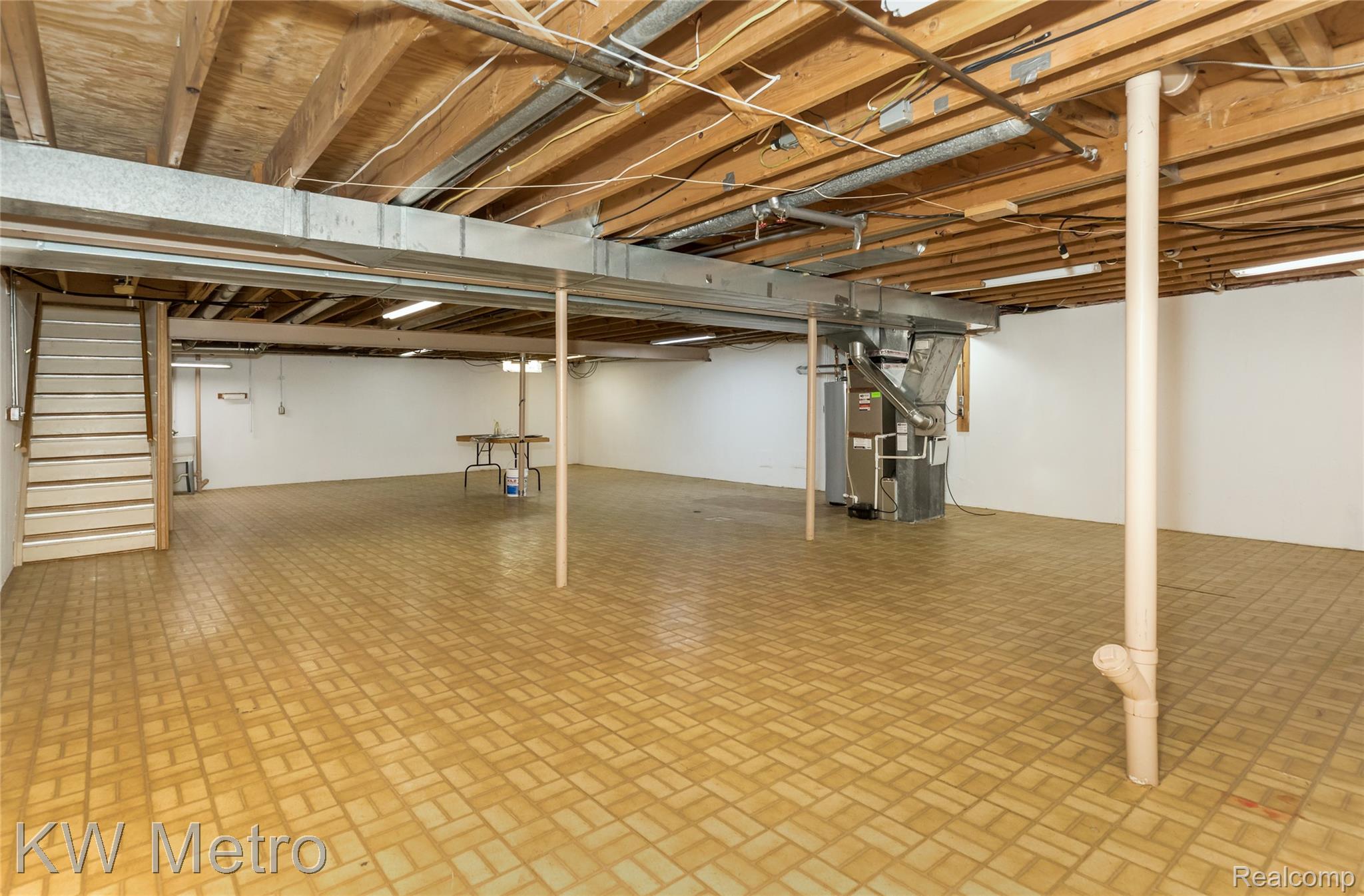 2154 Warrington Road Rochester, MI 48307 - Photo 28 of 41 Expansive lower level featuring exposed ceiling joists, light-colored floor tiles, and painted white walls
