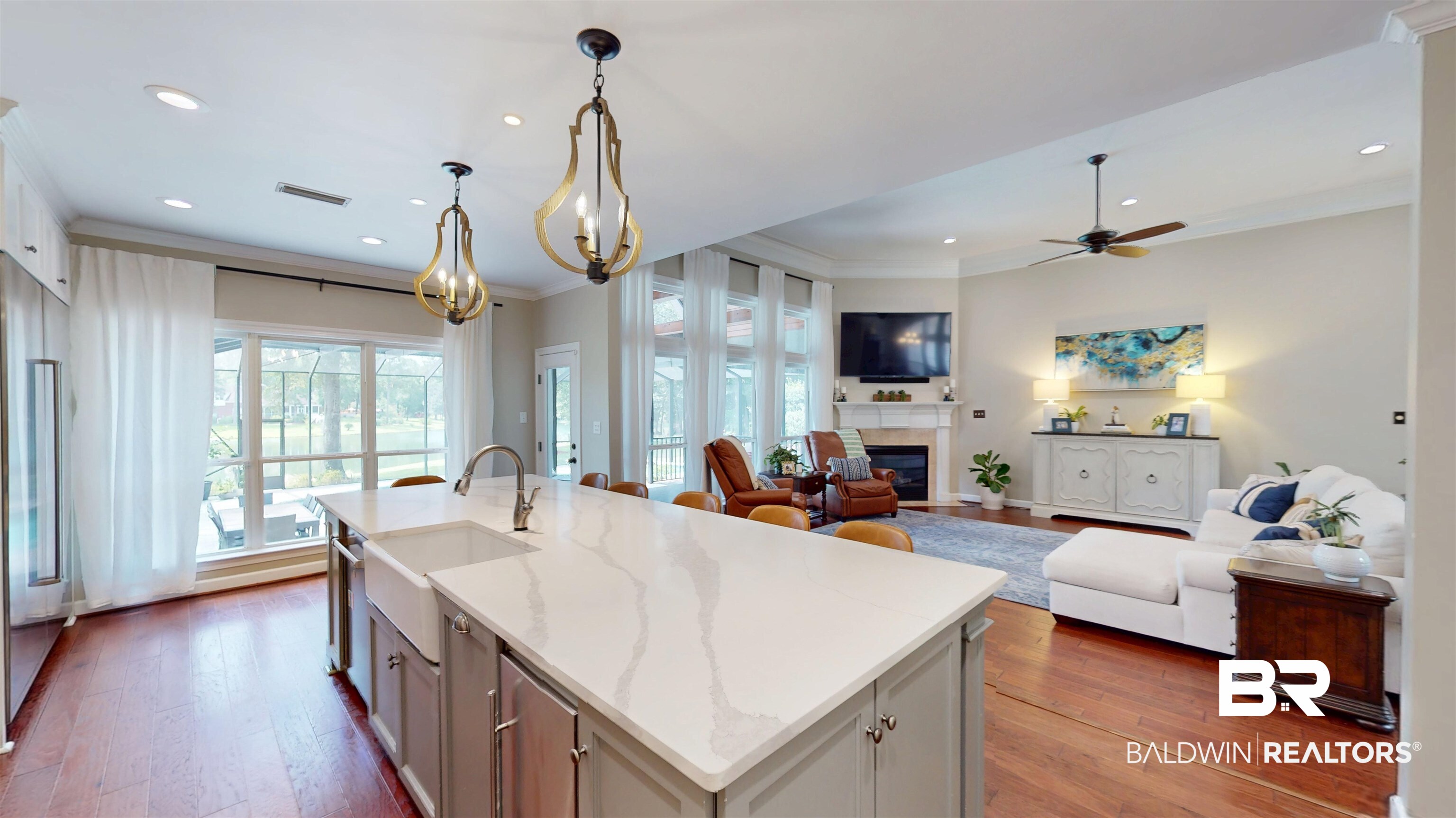 8775 Dawes Lake Road North Mobile, AL 36619 - Photo 58 of 59 Kitchen featuring hardwood / wood-style flooring, ornamental molding, a glass covered fireplace, open floor plan, and a kitchen island with sink