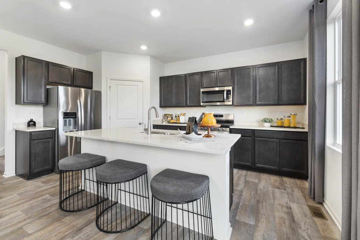 Undisclosed Address Elgin, IL 60124 - Photo 5 of 19 a kitchen with granite countertop stainless steel appliances a stove a refrigerator and a dining table with wooden floor