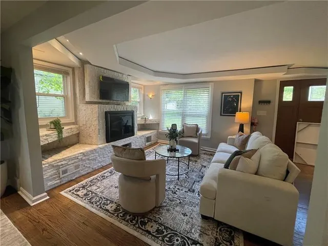 a living room with furniture a fireplace and a flat screen tv
