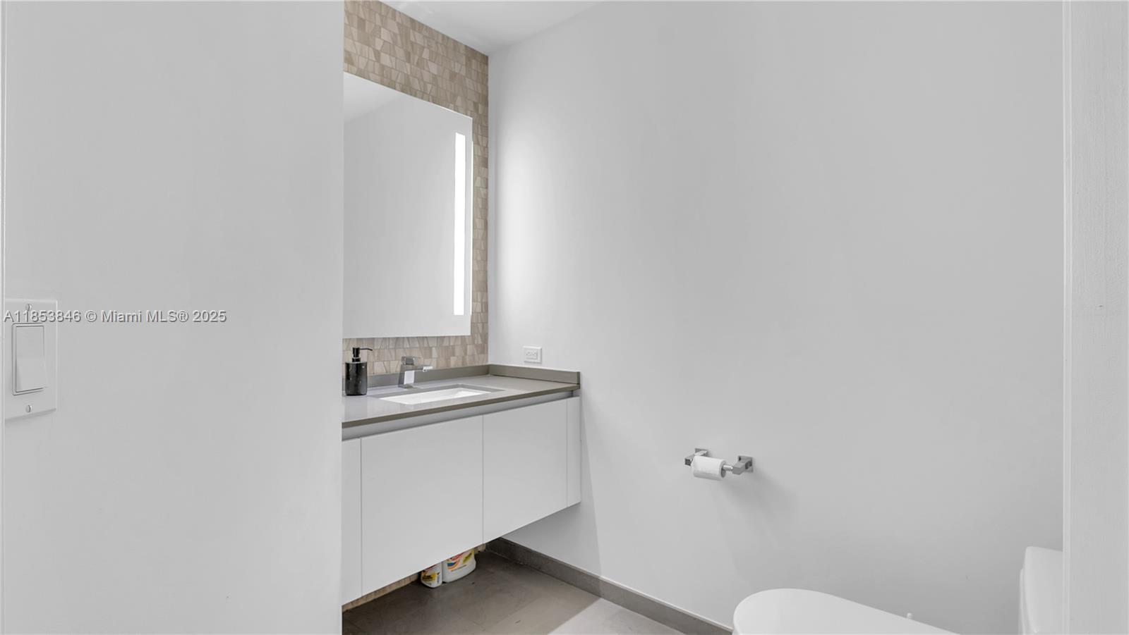 88 Southwest 7th Street, Unit 2312 Miami, FL 33130 - Photo 20 of 34 a bathroom with a granite countertop sink toilet and mirror